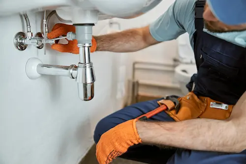 Fontanero urgente reparando una fuga de agua en una vivienda